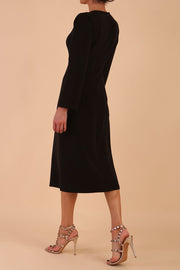 Model wearing diva catwalk in Bombay fabric the Epsom Long Sleeve and round neckline and midi A-Line Dress in Black colour back side