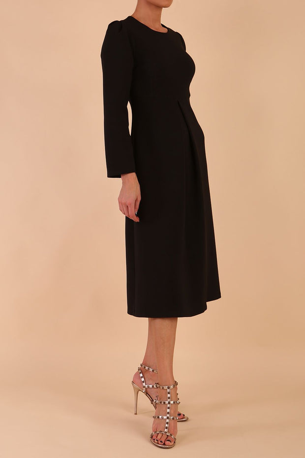 Model wearing diva catwalk in Bombay fabric the Epsom Long Sleeve and round neckline and midi A-Line Dress in Black colour front side