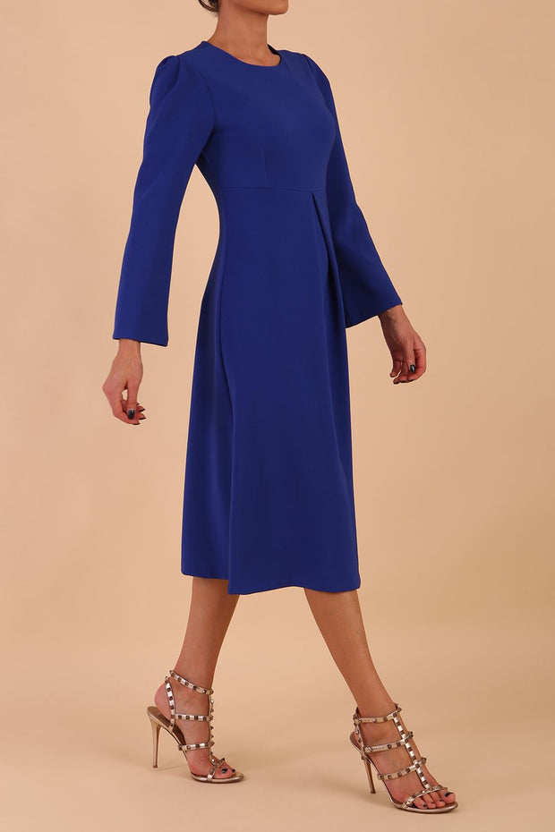 Model wearing diva catwalk in Bombay fabric the Epsom Long Sleeve and round neckline and midi A-Line Dress in Royal Blue colour front side
