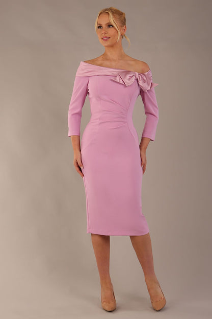 brunette Model is wearing a diva catwalk Rosalind Off Shoulder Bow Detail Pencil Dress 3/4 sleeve in Dawn Pink contrast front image (Dawn Pink)