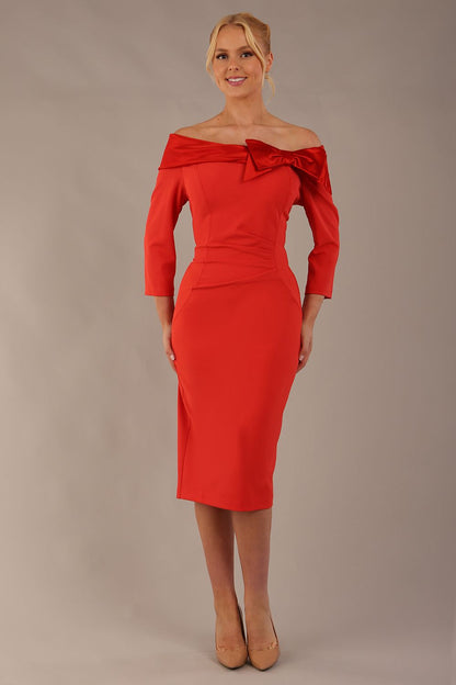 brunette Model is wearing a diva catwalk Rosalind Off Shoulder Bow Detail Pencil Dress 3/4 sleeve in Fiesta Orange/Fire Orange contrast front image (Fiesta Orange / Fire Orange Contrast)