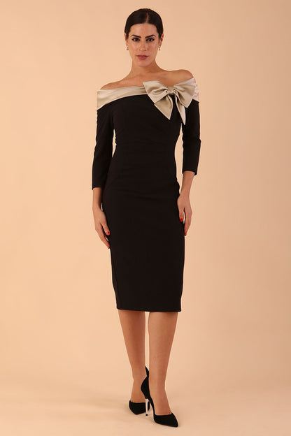 Model wearing a Rosalind Off Shoulder Bow Detail Pencil Dress 3/4 sleeve in Black/Champagne contrast