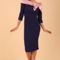 Model wearing a Rosalind Off Shoulder Bow Detail Pencil Dress 3/4 sleeve in Navy Blue/ Pink contrast