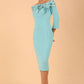 Model wearing a Rosalind Off Shoulder Bow Detail Pencil Dress 3/4 sleeve in Turquoise colour 