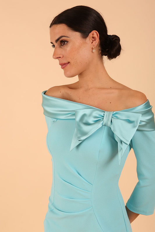 Model wearing a Rosalind Off Shoulder Bow Detail Pencil Dress 3/4 sleeve in Turquoise colour close up 