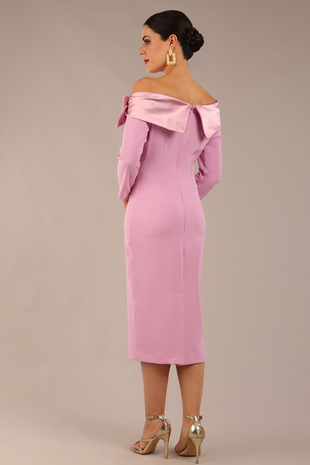 brunette Model is wearing a diva catwalk Rosalind Off Shoulder Bow Detail Pencil Dress 3/4 sleeve in Dawn Pink contrast back image