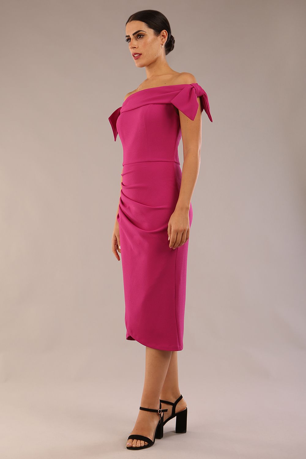 model is wearing a diva catwalk Strand Off-Shoulder Bow Tie Dress midi length and pleated skirt in magenta haze colour