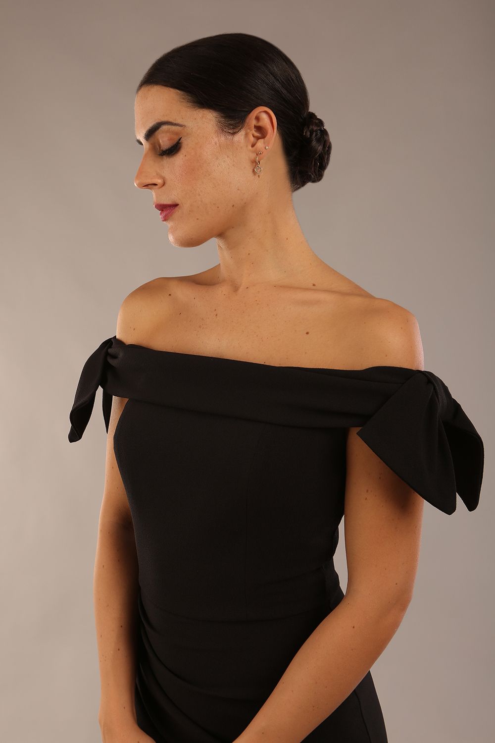 model is wearing a diva catwalk Strand Off-Shoulder Bow Tie Dress midi length and pleated skirt in black colour