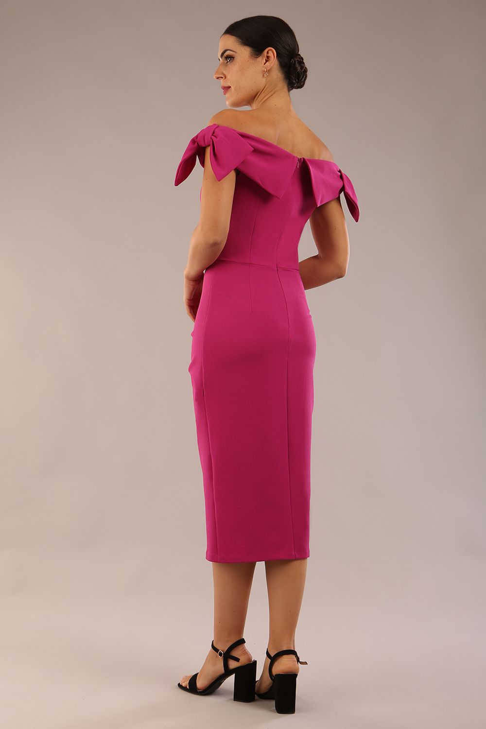 model is wearing a diva catwalk Strand Off-Shoulder Bow Tie Dress midi length and pleated skirt in magenta haze colour back