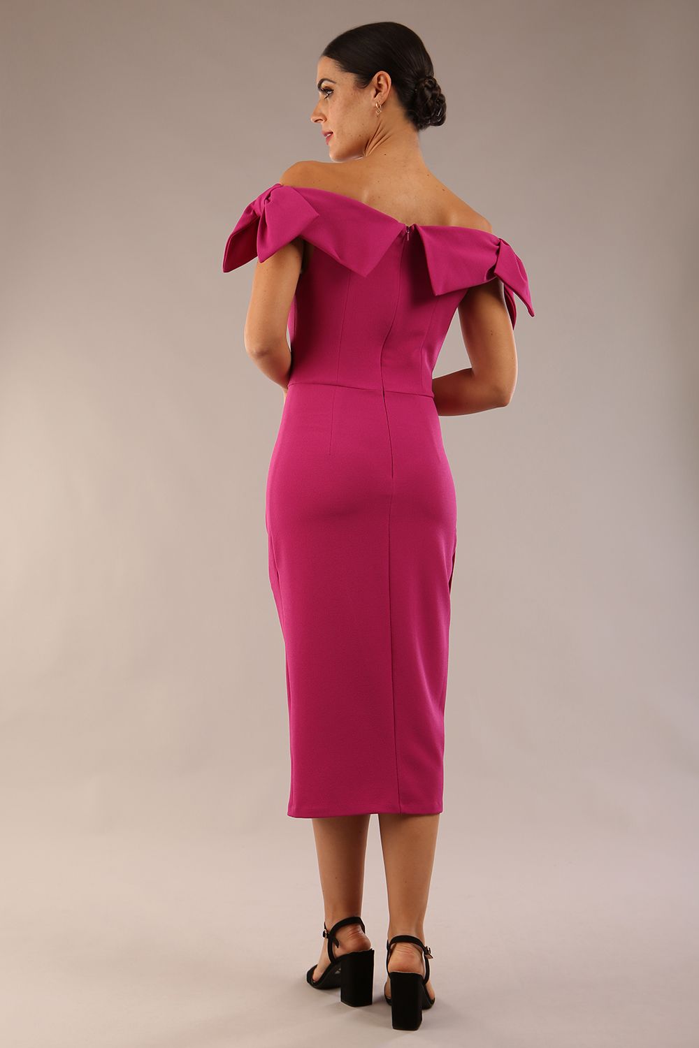 model is wearing a diva catwalk Strand Off-Shoulder Bow Tie Dress midi length and pleated skirt in magenta haze colour