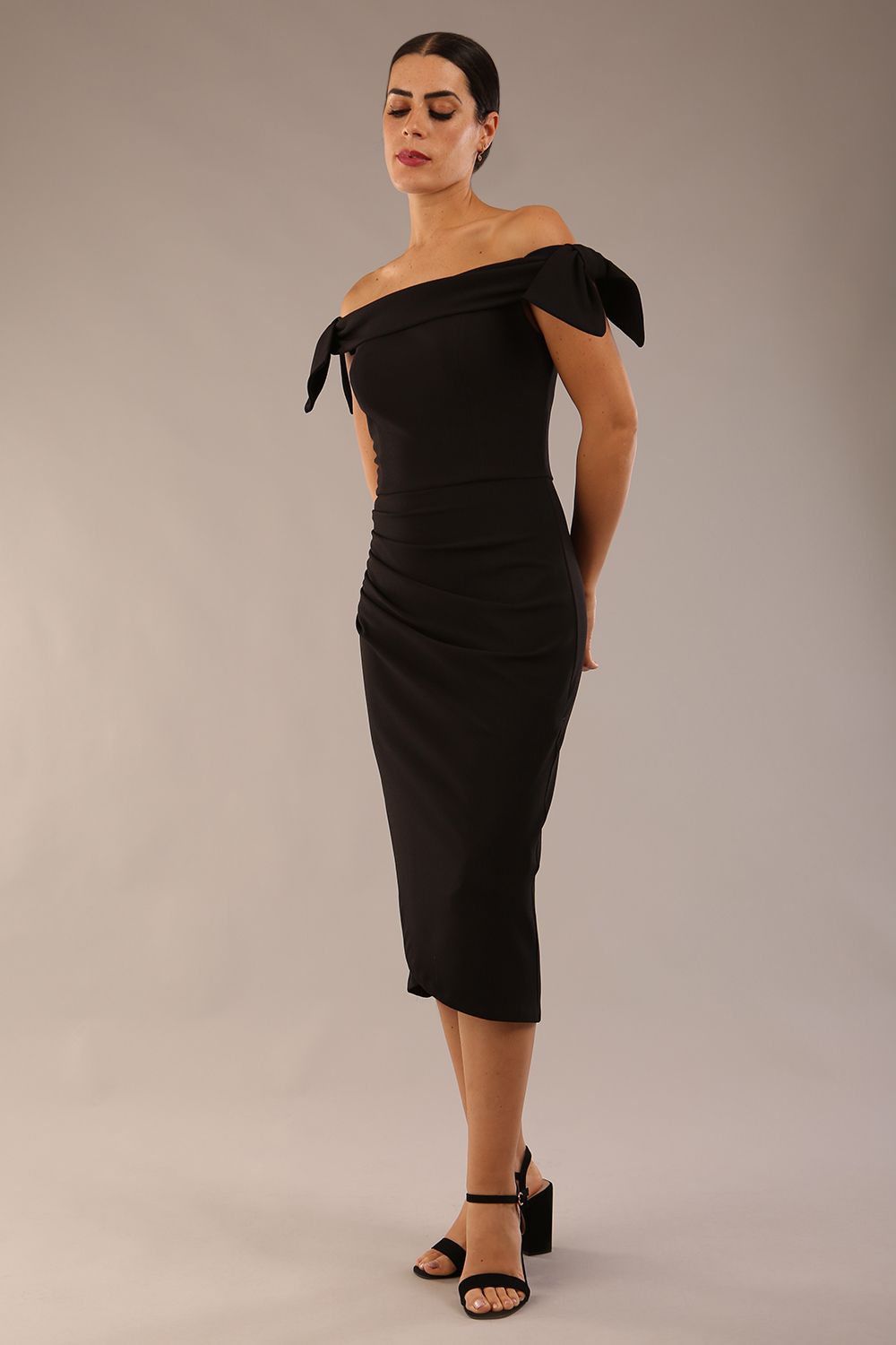 model is wearing a diva catwalk Strand Off-Shoulder Bow Tie Dress midi length and pleated skirt in black colour