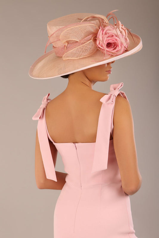 brunette model wearing a diva catwalk Philippa Pencil Wiggle Dress sleeveless style, tie detail on the shoulders knee length and sweetheart neckline in crystal pink colour back with hat