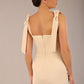 brunette model wearing a diva catwalk Philippa Pencil Wiggle Dress sleeveless style, tie detail on the shoulders knee length and sweetheart neckline in sandshell beige back