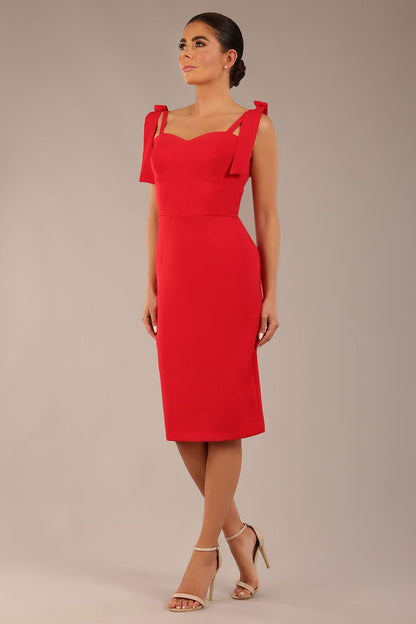 brunette model wearing a diva catwalk Philippa Pencil Wiggle Dress sleeveless style, tie detail on the shoulders knee length and sweetheart neckline in scarlet red colour front 