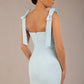 brunette model wearing a diva catwalk Philippa Pencil Wiggle Dress sleeveless style, tie detail on the shoulders knee length and sweetheart neckline in sky blue colour back
