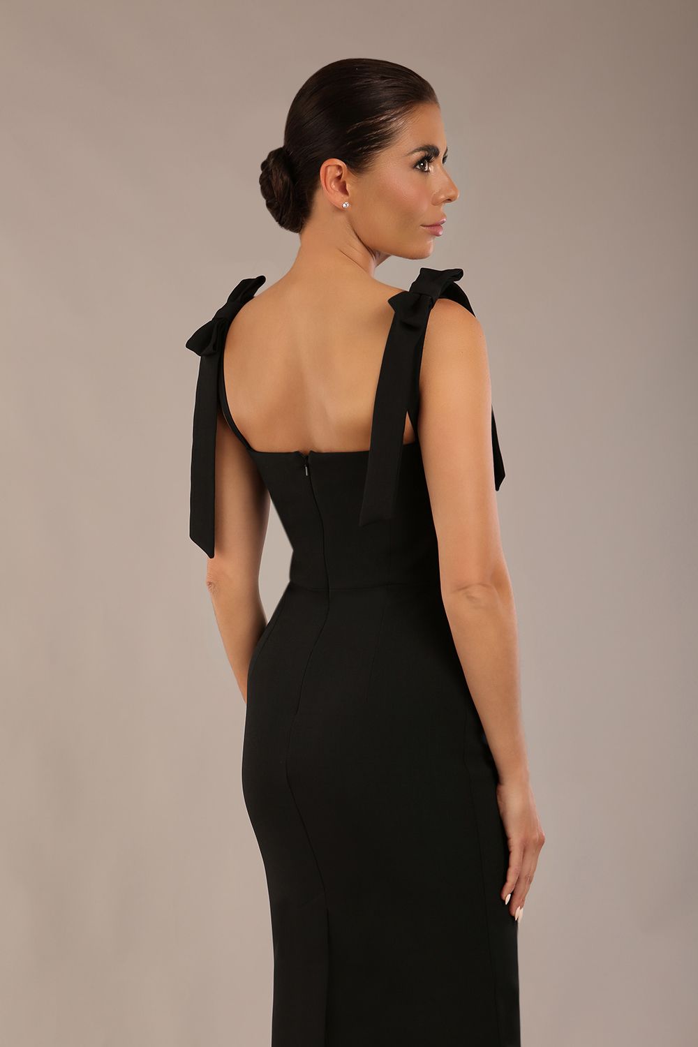 brunette model wearing a diva catwalk Philippa Pencil Wiggle Dress sleeveless style, tie detail on the shoulders knee length and sweetheart neckline in black colour back