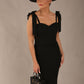 brunette model wearing a diva catwalk Philippa Pencil Wiggle Dress sleeveless style, tie detail on the shoulders knee length and sweetheart neckline in black colour front with hat