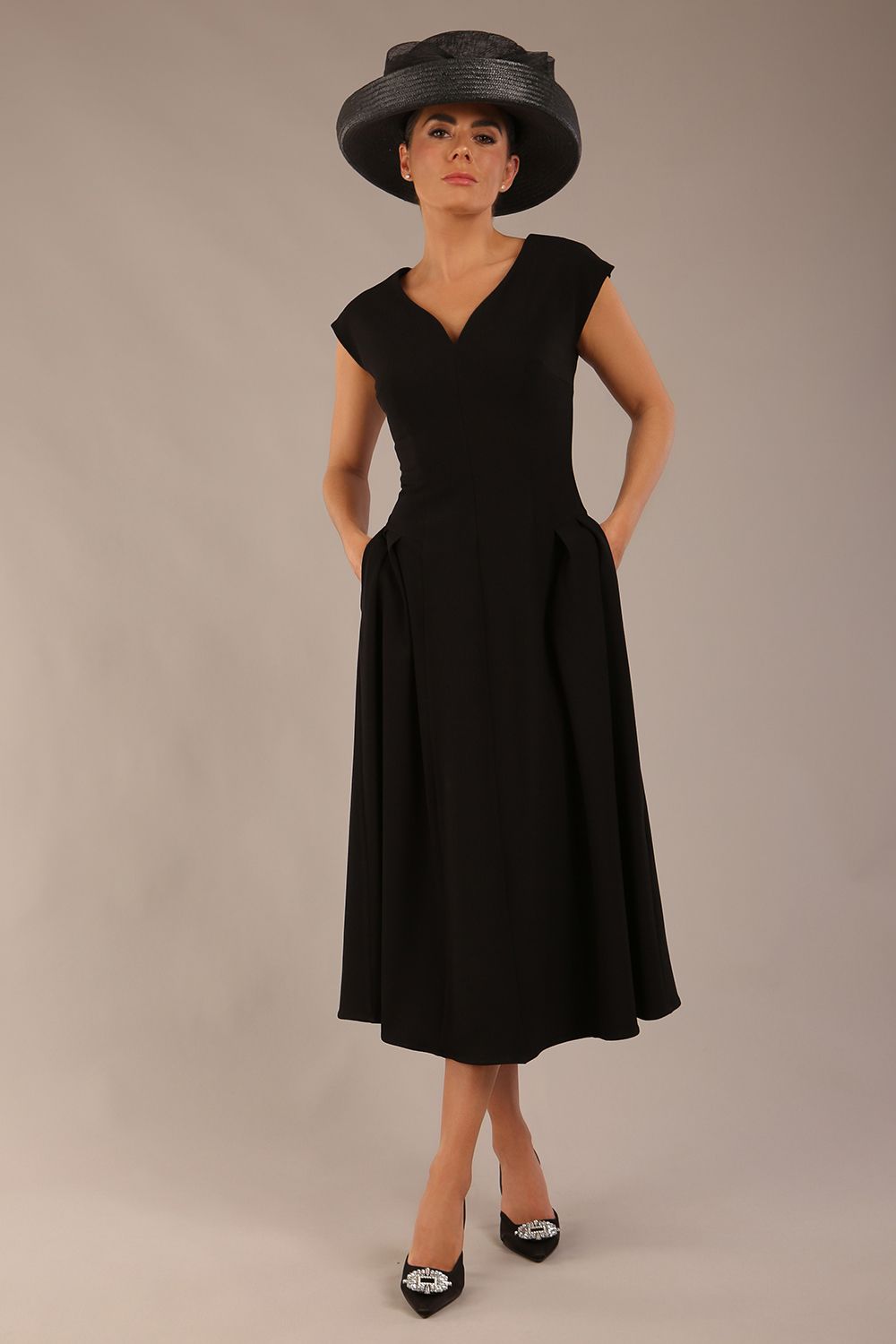 brunette model is wearing a diva catwalk Audrey a-line Dress sweetheart neckline and With Pockets and sleeveless with ankle length black colour front