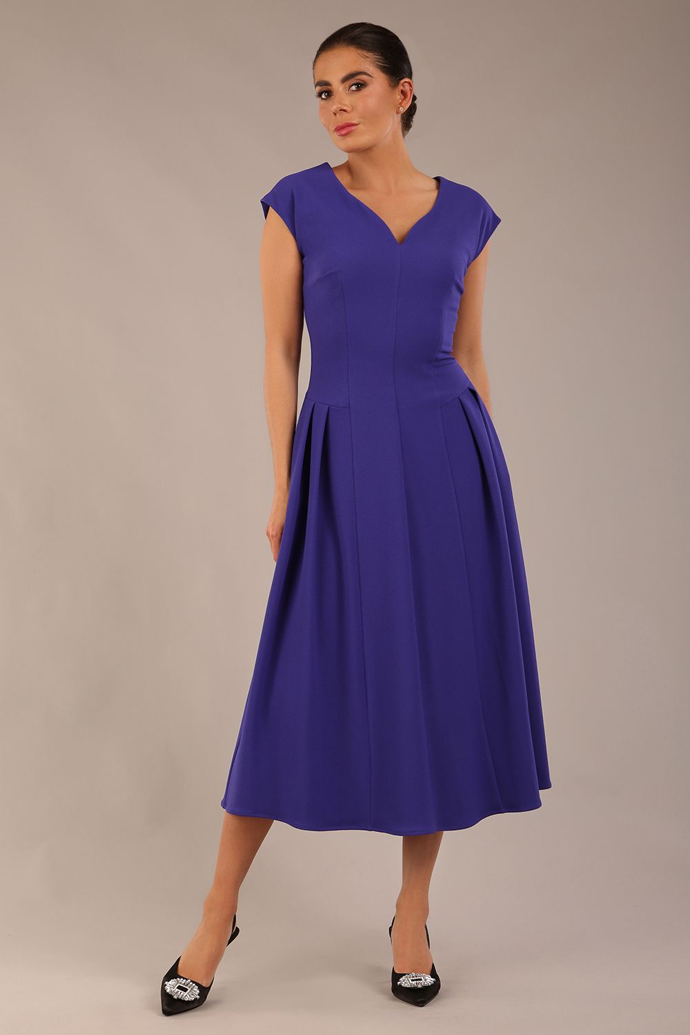 brunette model is wearing a diva catwalk Audrey a-line Dress sweetheart neckline and With Pockets and sleeveless with ankle length inspectrum indigo colour front