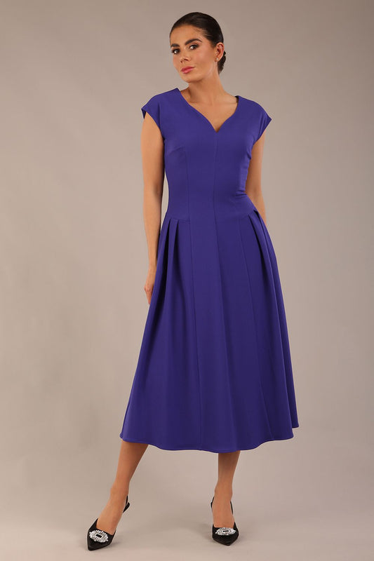 brunette model is wearing a diva catwalk Audrey a-line Dress sweetheart neckline and With Pockets and sleeveless with ankle length inspectrum indigo colour front