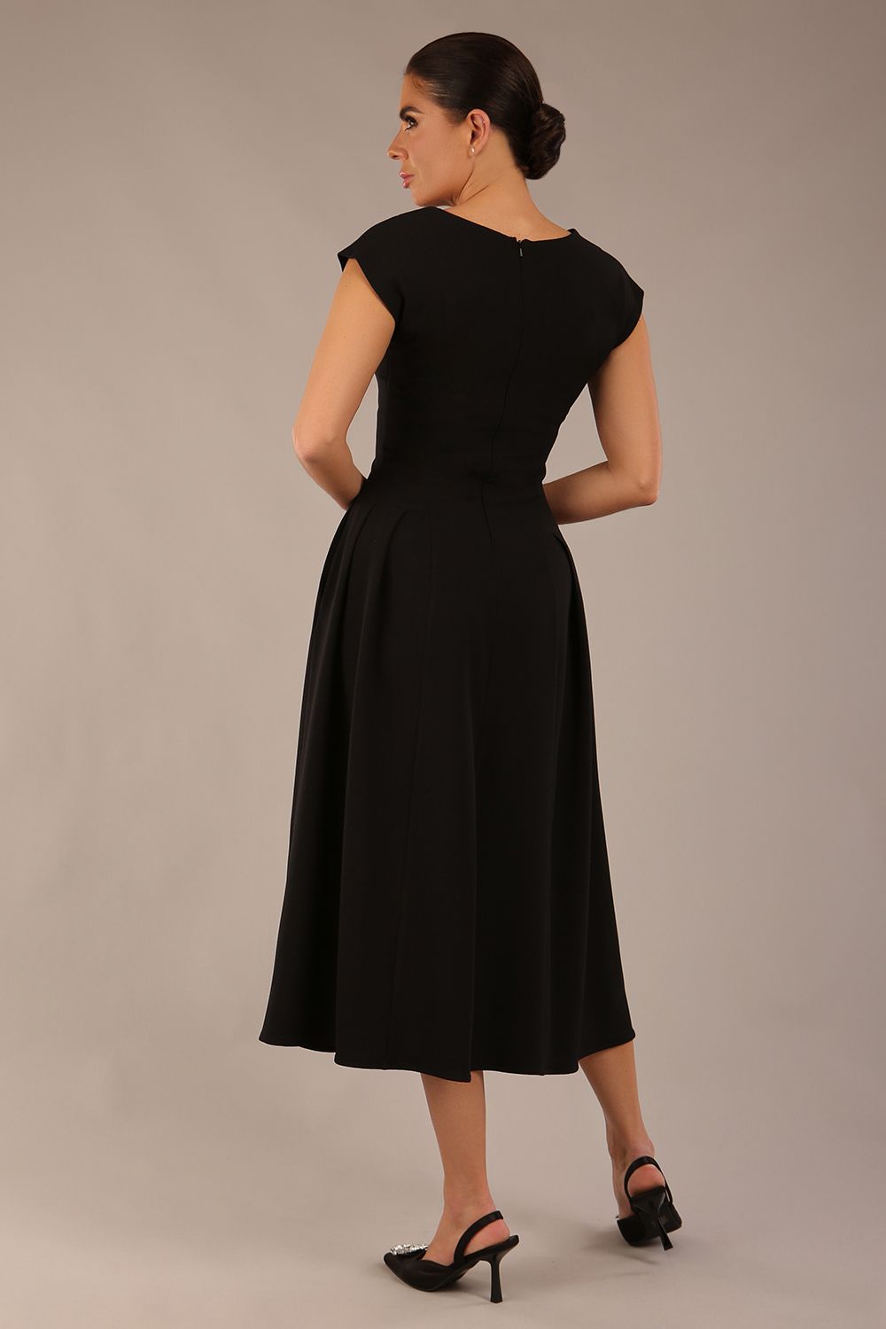 brunette model is wearing a diva catwalk Audrey a-line Dress sweetheart neckline and With Pockets and sleeveless with ankle length black colour back
