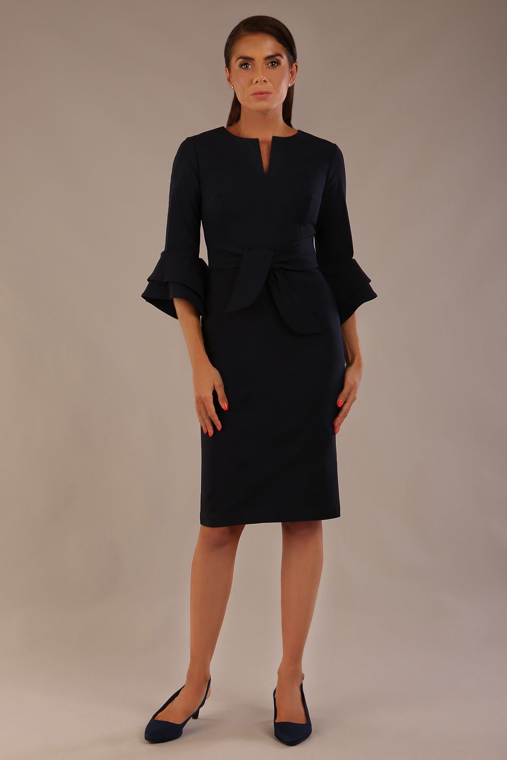 brunette model is wearing a diva catwalk Hobson ruffled sleeves Pencil Dress with tie waistband knee length in Dark Navy colour front