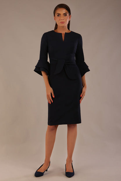 brunette model is wearing a diva catwalk Hobson ruffled sleeves Pencil Dress with tie waistband knee length in Dark Navy colour front