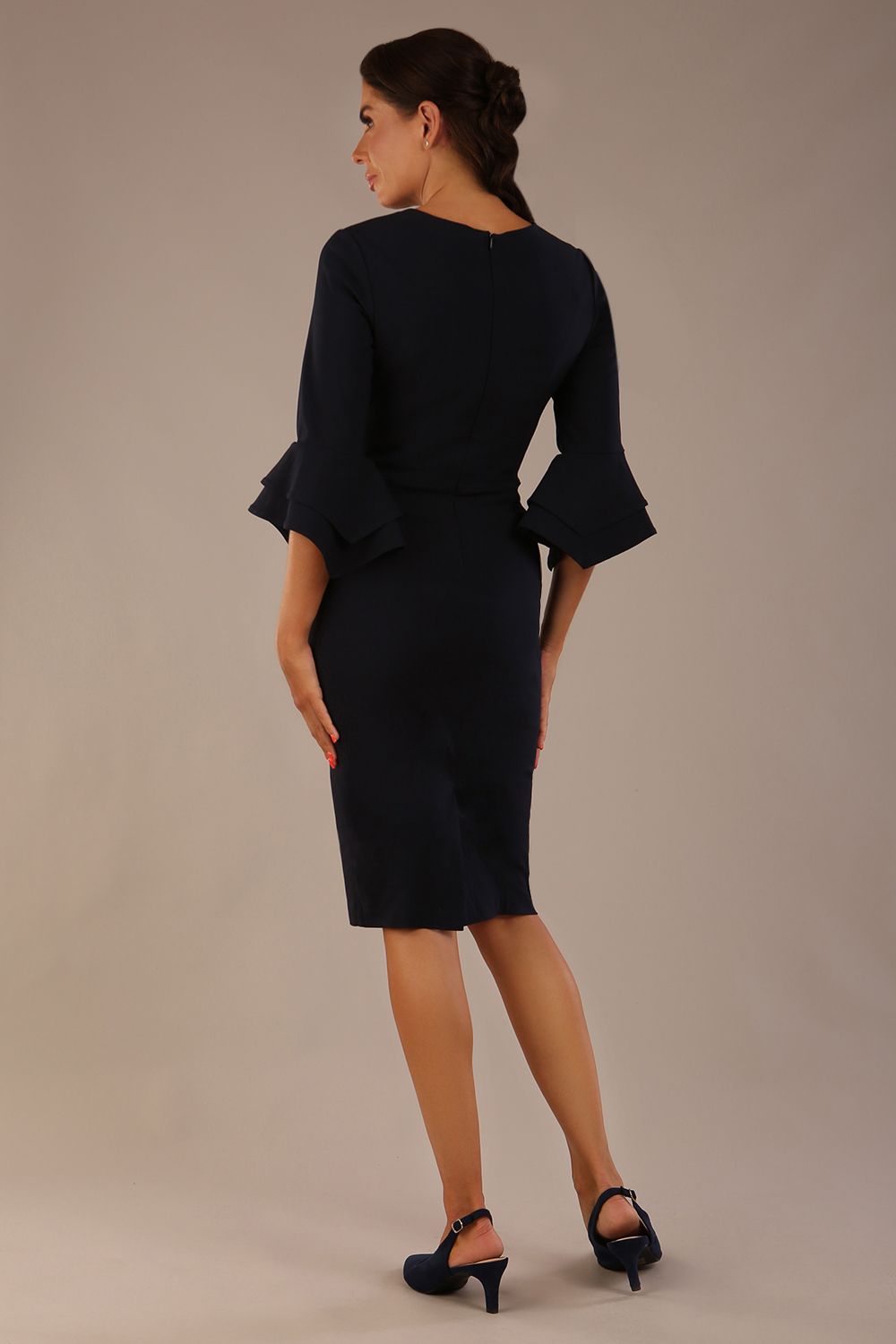 brunette model is wearing a diva catwalk Hobson ruffled sleeves Pencil Dress with tie waistband knee length in Dark Navy colour back