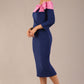 Brunette Model is wearing a Rosalind Off Shoulder Bow Detail Pencil Dress 3/4 sleeve in Navy Blue/ Pink contrast front image