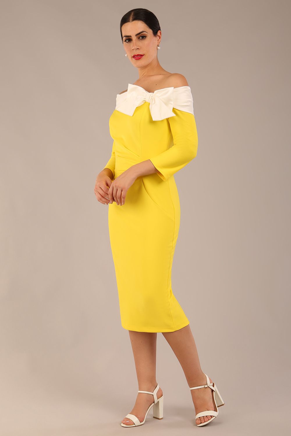 brunette Model is wearing a Rosalind Off Shoulder Bow Detail Pencil Dress 3/4 sleeve in Blazing Yellow / Ivory cream contrast front image