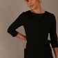 Woman wearing a Heathcote Floral Detail Pencil Dress with a plain background in black close up view