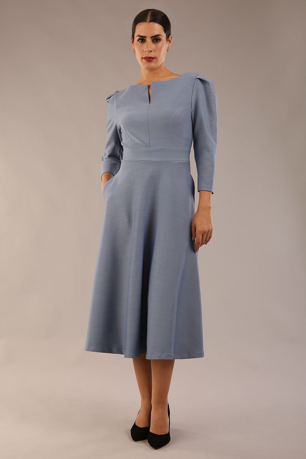 A model wearing a red, 3/4 sleeve A-line dress with pockets, featuring a boat neckline and vent at the centre back (Steel Blue)