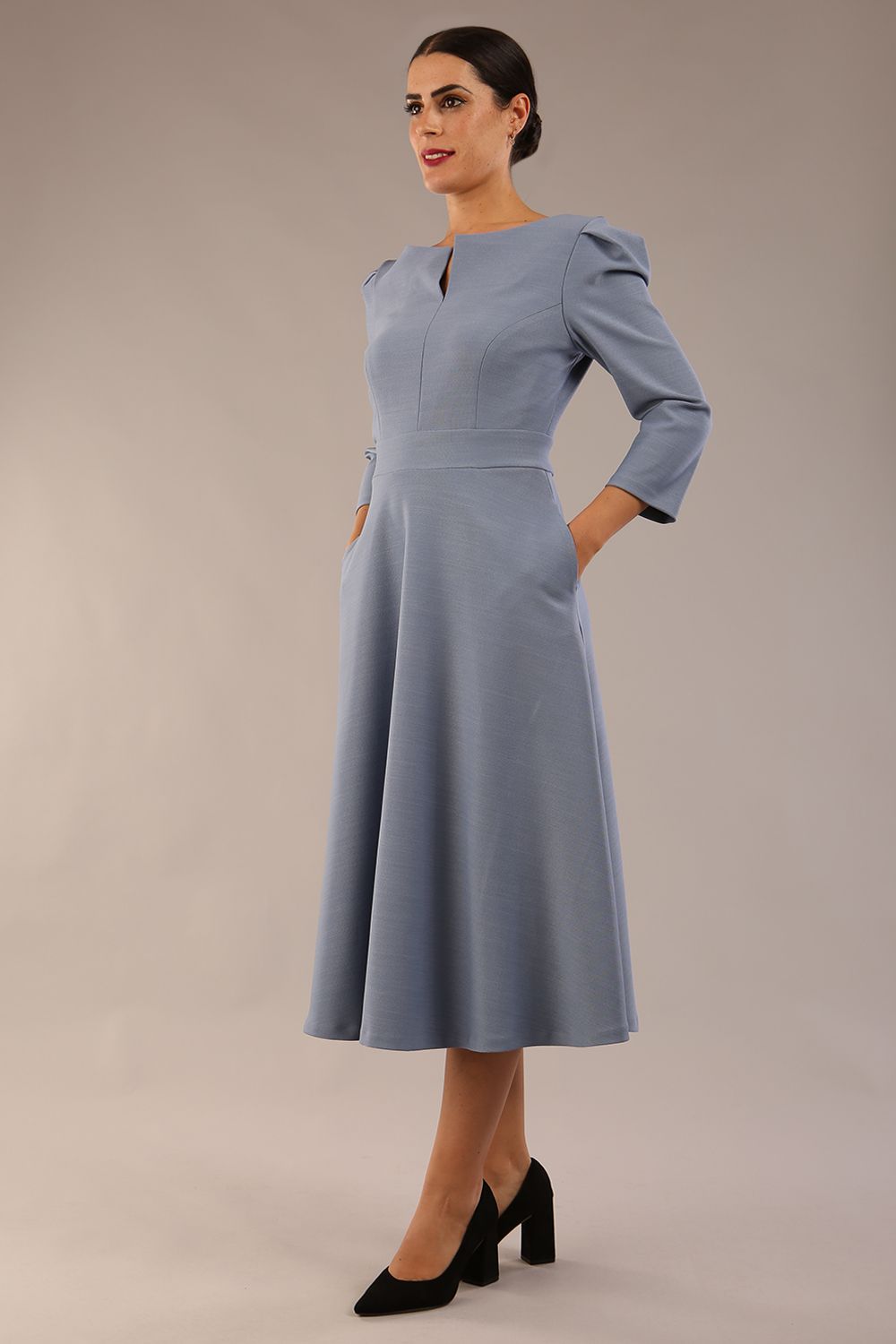 A model wearing a red, 3/4 sleeve A-line dress with pockets, featuring a boat neckline and vent at the centre back (Steel Blue)