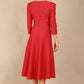 A model wearing a red, 3/4 sleeve A-line dress with pockets, featuring a boat neckline and vent at the centre back (Crimson Pink)