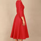 A model wearing a red, 3/4 sleeve A-line dress with pockets, featuring a boat neckline and vent at the centre back (Crimson Pink)