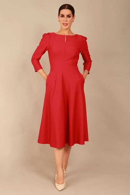 A model wearing a red, 3/4 sleeve A-line dress with pockets, featuring a boat neckline and vent at the centre back (Crimson Pink)