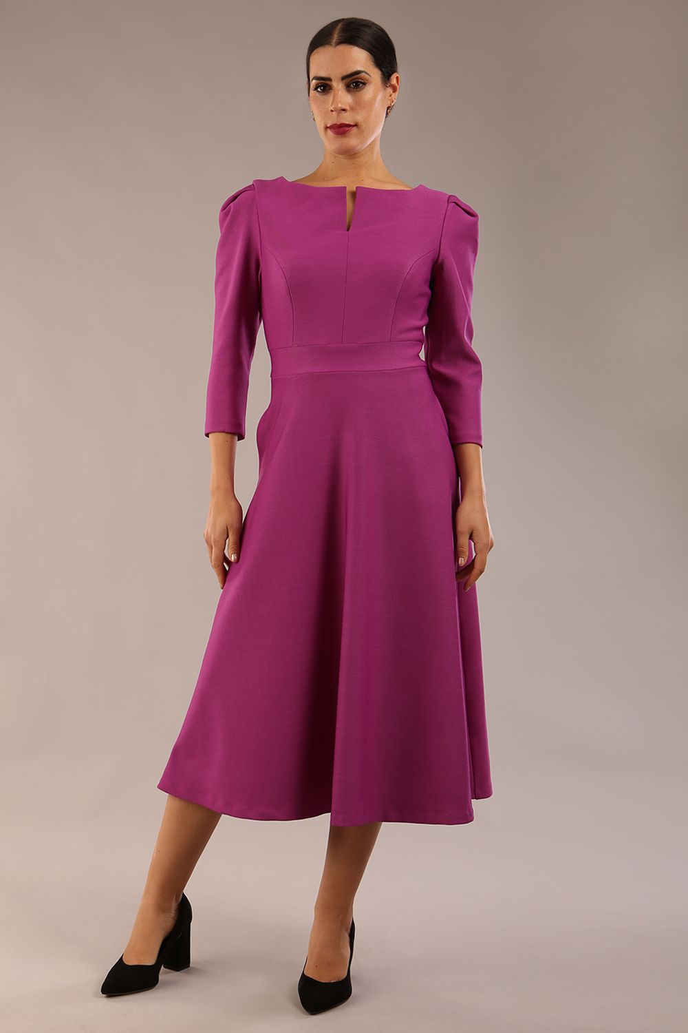 A model wearing a red, 3/4 sleeve A-line dress with pockets, featuring a boat neckline and vent at the centre back (Dawn Purple)