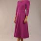 A model wearing a red, 3/4 sleeve A-line dress with pockets, featuring a boat neckline and vent at the centre back (Dawn Purple)