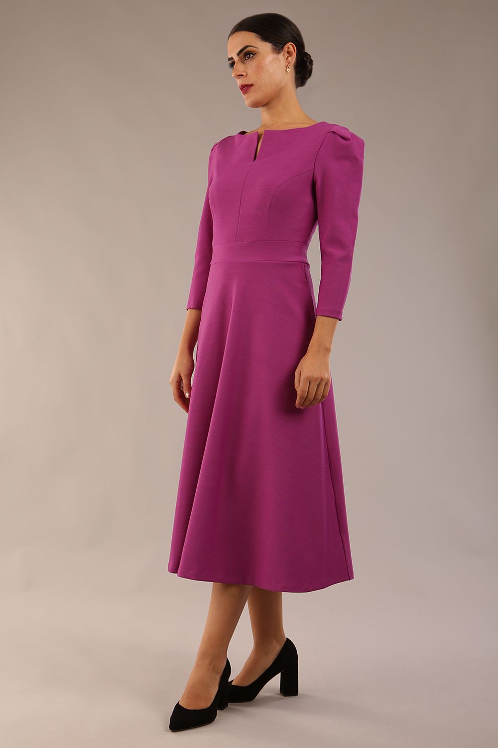 A model wearing a red, 3/4 sleeve A-line dress with pockets, featuring a boat neckline and vent at the centre back (Dawn Purple)