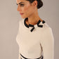  Model wearing the diva catwalk SEED Bethany bow detail pencil dress in sandy cream with black trim (Sandy Cream / Black)