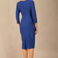 A woman modeling the diva catwalk  SEED Dolores cascade ruffle pencil dress in Monaco blue with a v-neckline and concealed zip at the back (Monaco Blue)