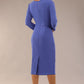A woman modeling the diva catwalk  SEED Dolores cascade ruffle pencil dress in thistle blue with a v-neckline and concealed zip at the back (Thistle blue)