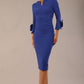 Model wearing the diva catwalk SEED Cicely rosette cuff pencil dress highlighting the asymmetric pleated waist and sculpted fit (Monaco Blue)