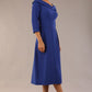 A model wearing a diva catwalk SEED Chrysanta sculptural collar dress 3/4 sleeve A-line dress with a round neckline and concealed zip at the back (Monaco Blue)