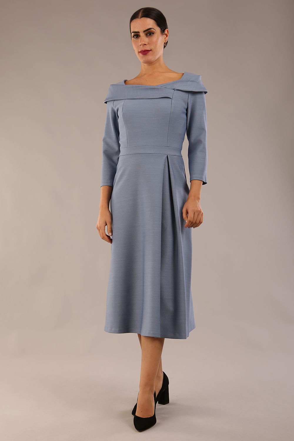 A model wearing a diva catwalk SEED Chrysanta sculptural collar dress 3/4 sleeve A-line dress with a round neckline and concealed zip at the back (Steel Blue)