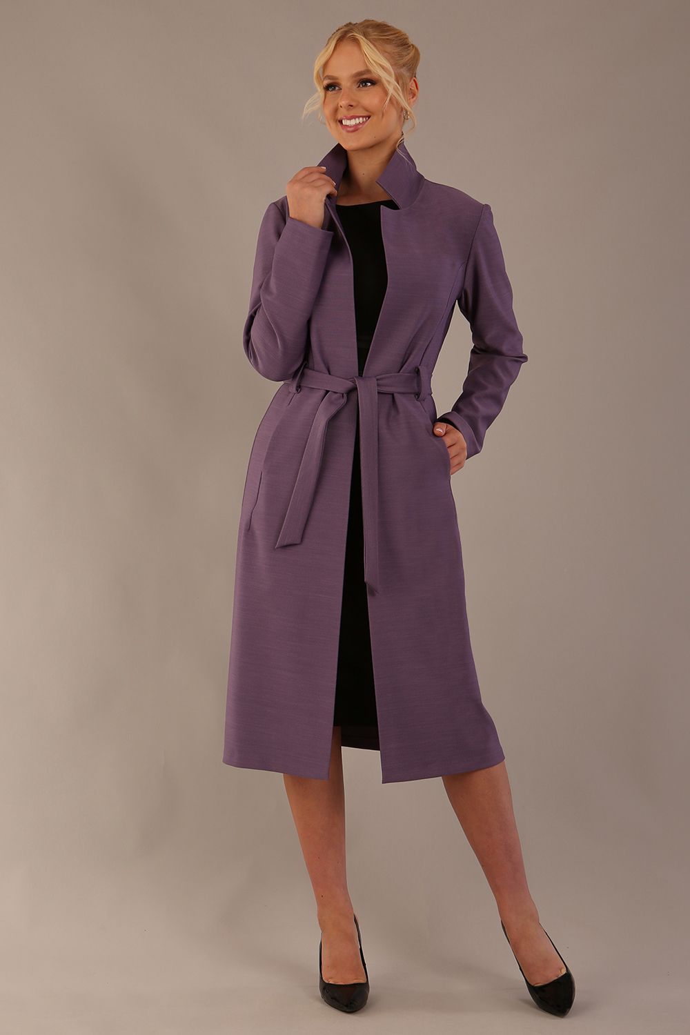 Woman wearing a long purple coat against a plain background (Dusky Lilac)