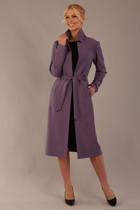 Woman wearing a long purple coat against a plain background (Dusky Lilac)