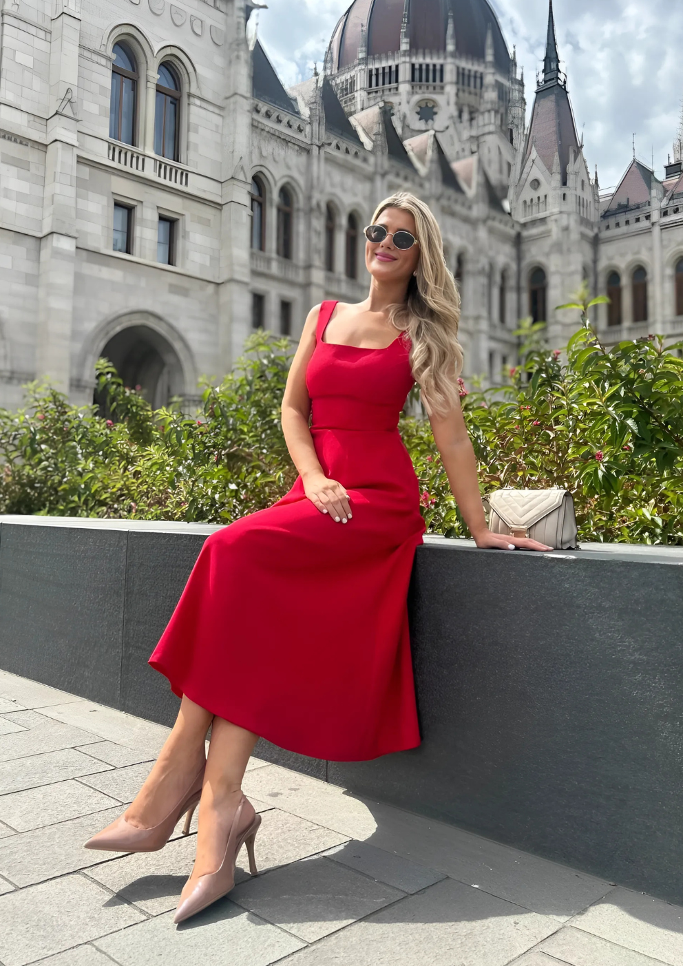 woman wearing a diva catwalk Tamsin Square Neckline Swing Dress sleeveless style with a midaxi  length and side pockets in Scarlet Red colour in Budapest