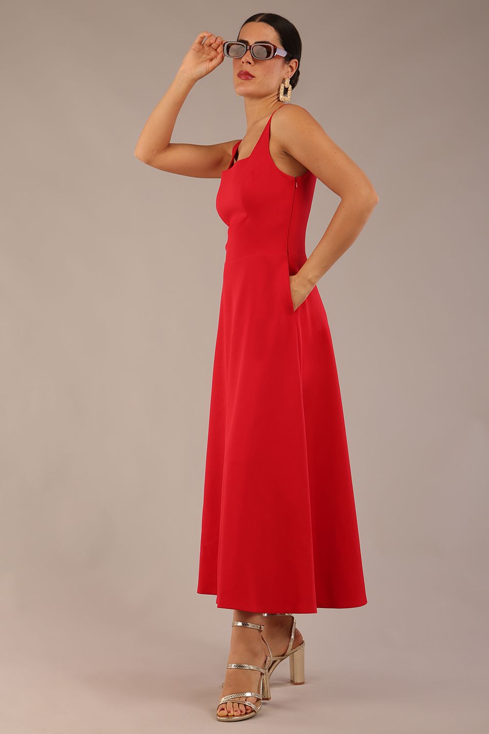 model wearing a diva catwalk Tamsin Square Neckline Swing Dress sleeveless style with a midaxi  length and side pockets in Scarlet Red colour