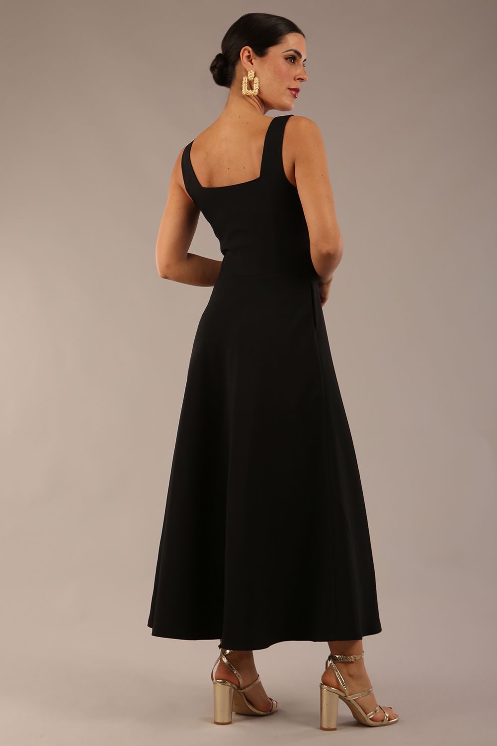 model wearing a diva catwalk Tamsin Square Neckline Swing Dress sleeveless style with a midaxi  length and side pockets in Black colour